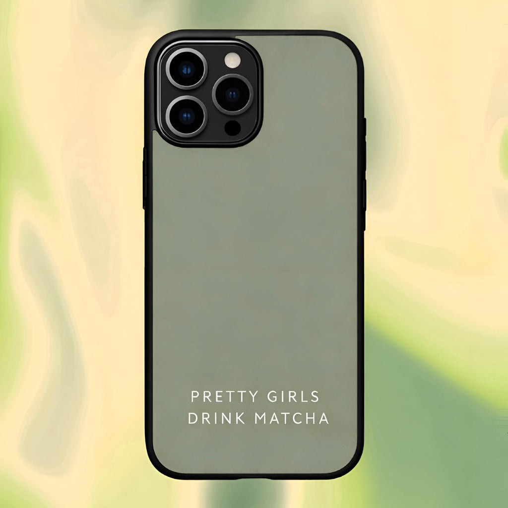 Phone case with 'Pretty Girls Drink Matcha' text on a blurred green background